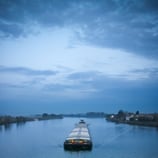 sailboat-sailing-river-against-sky-1