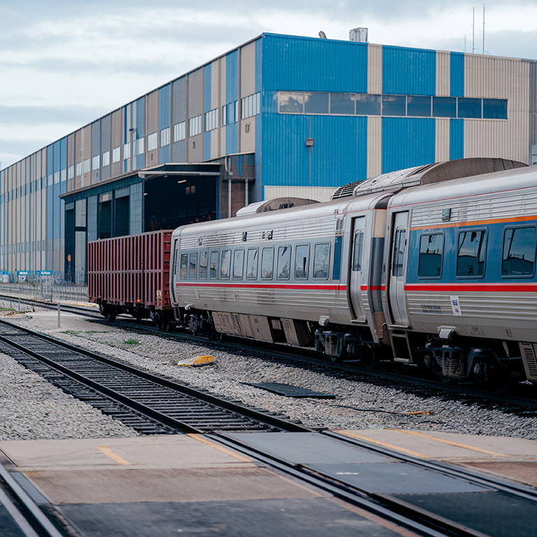 train-is-pulling-train-with-red-stripe-down-side